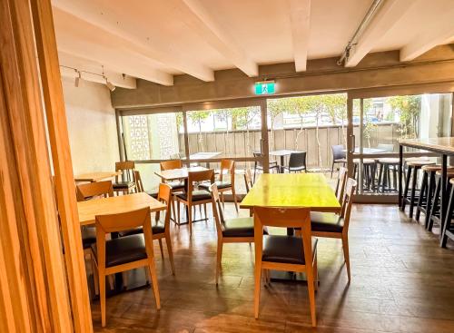 a dining room with wooden tables and chairs and tablesktop at Noa Hotel in Auckland