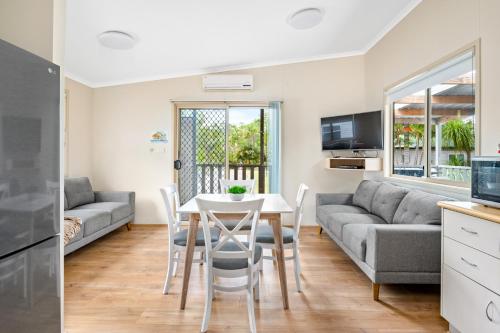 a living room with a table and a couch at Koala Shores Holiday Park in Lemon Tree Passage