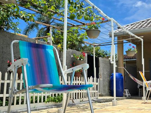 a pair of chairs sitting on a patio at Casa das Flores com piscina in Matinhos