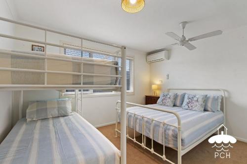 a bedroom with two bunk beds and a ceiling fan at Wyrallah House - Stay 5 Nights PAY 4 - Jan 1-22 in Lakes Entrance