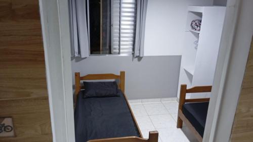 una piccola stanza con un letto e una finestra di Apto - Relax aqui é Praia a Bertioga