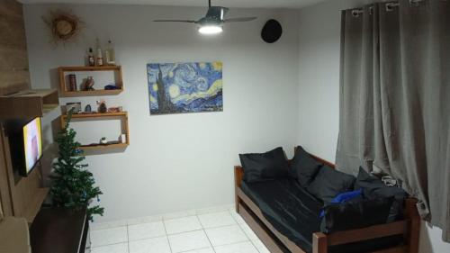 un soggiorno con un divano e un quadro sul muro di Apto - Relax aqui é Praia a Bertioga