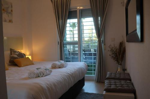 een slaapkamer met een groot bed met handdoeken erop bij May O'Dea Suite in Orihuela-Costa