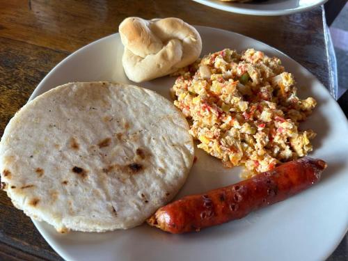 普韦布洛保FINCA HOTEL LAS CABAÑAS DEL Parque的一盘食物，里面有一根香肠和一张玉米饼。