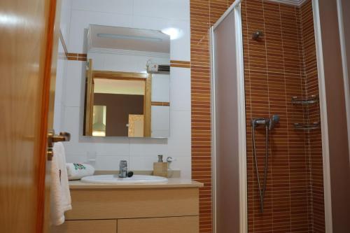 een badkamer met een wastafel en een spiegel bij May O'Dea Suite in Orihuela-Costa