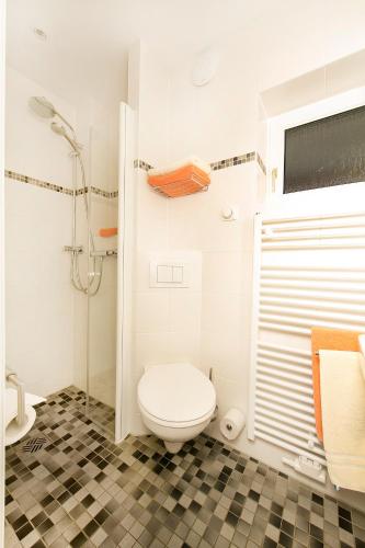 a white bathroom with a toilet and a shower at Ferienhotel Bernstein in Trassenheide