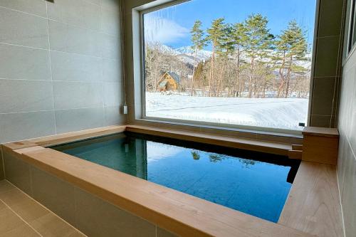 a swimming pool in a room with a window at Vive Boutique Hotel - Echoland in Hakuba