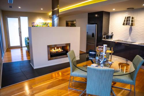 a kitchen and dining room with a table and a fireplace at The Frames - Award-Winning Couples Retreat with Private Heated Pool, Spa & Sauna in Renmark
