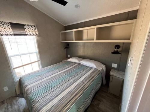 een kleine slaapkamer met een bed en een raam bij Serene Tiny Home - Biker-Friendly, Close to Skyway in Tellico Plains