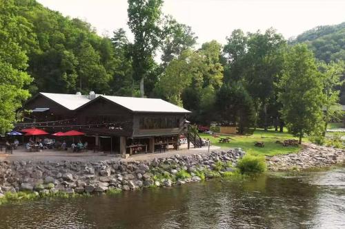 een restaurant naast een rivier met een rotswand bij Serene Tiny Home - Biker-Friendly, Close to Skyway in Tellico Plains