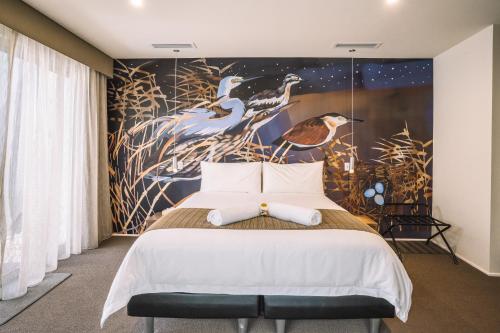 una camera da letto con un letto e una parete con uccelli di The Frames a Renmark