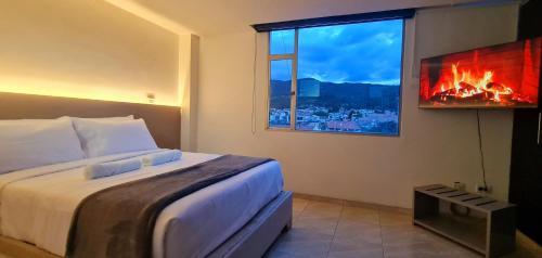 a bedroom with a bed with a fire in a window at Posada Pa'sumerce in Tibasosa