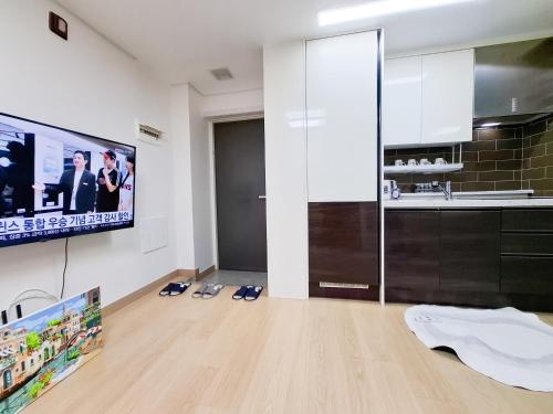Una sala de estar con un televisor de pantalla plana en una pared. en 금천구 디지털단지 빌라, en Seúl