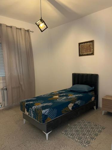 a bedroom with a bed in a room with a window at Coquette-Appart in Ez Zahra