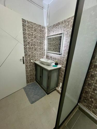 a bathroom with a sink and a mirror at Coquette-Appart in Ez Zahra