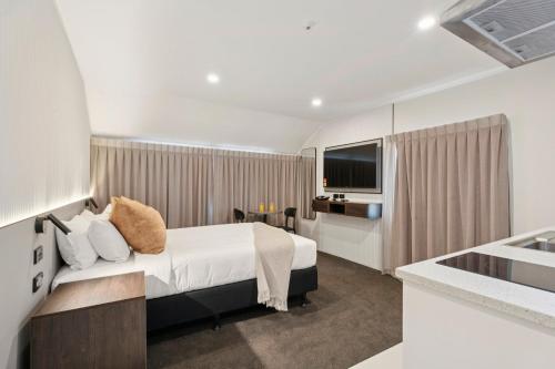 a hotel room with a bed and a kitchen at Sai Motels - Greenlane Auckland in Auckland