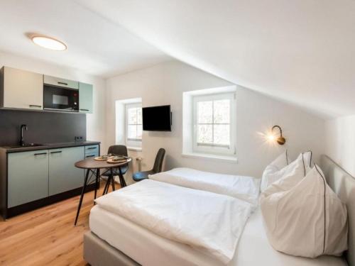 Un dormitorio con una cama blanca y una mesa. en Leni Top 4, en Dienten am Hochkönig