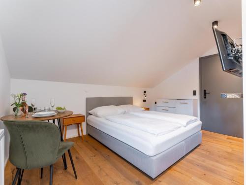 霍赫克尼希山麓丁滕Leni Top 6的一间卧室，里面有一张床、一张桌子和一把椅子