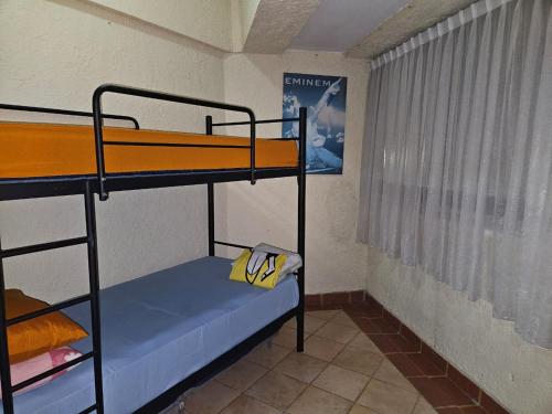 una stanza con due letti a castello e una finestra di Apartemen marbella anyer tower Nakula lt 2 view kolam renang & laut a Babagan