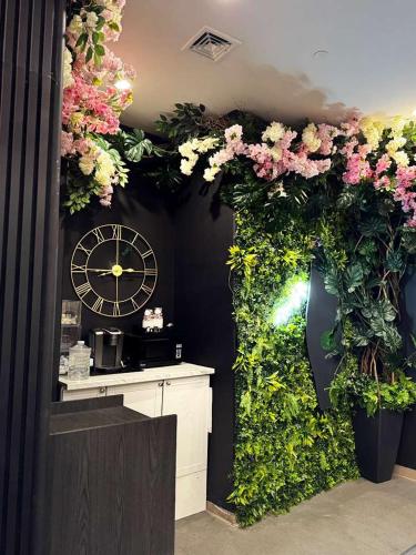 a room with a clock and flowers on the wall at Nova Hotel JFK in Hillside
