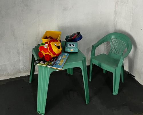 a green table and a chair with toys on it at Casa Brisa do Mar in Tamandaré