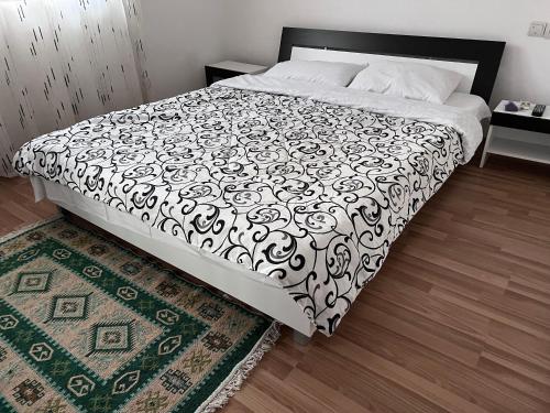 ein Schlafzimmer mit einem Bett mit einer schwarz-weißen Bettdecke in der Unterkunft Casa Isabela in Ocna Sibiului