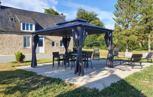 a table and chairs under a blue umbrella at Charmante Maison Au Calme in Saint-Clément