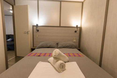 a bedroom with a bed with towels on it at Le Cottage 61 - Au Bonheur de Sophie in Le Vauclin