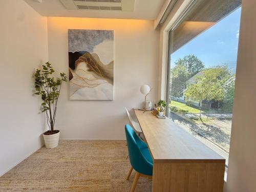 a home office with a desk and a large window at Vive Boutique Hotel - Echoland in Hakuba