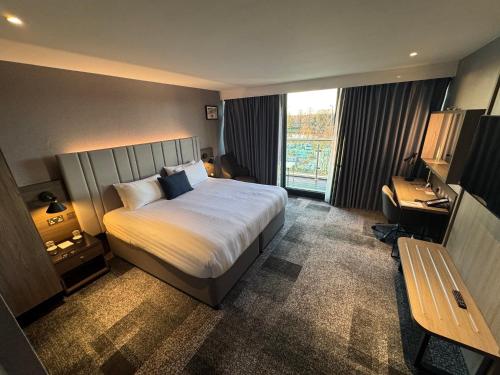 a hotel room with a bed and a desk at Crowne Plaza London - Kingston by IHG in Kingston upon Thames
