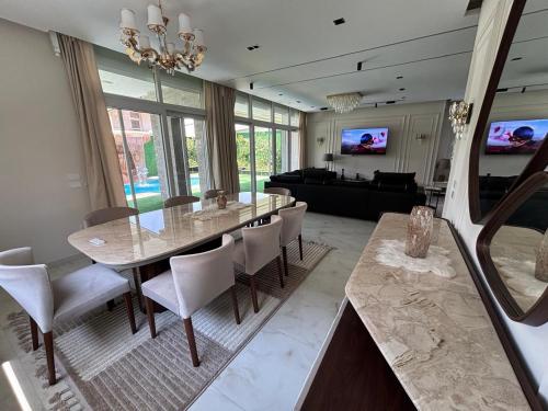 Una sala de estar con una mesa de comedor y un sofá. en 7 BR Private Entire Smart House with Heated Pool, Waterfall, Garden, en El Cairo