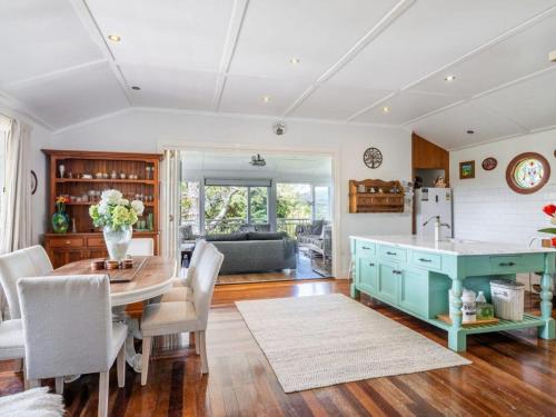 a kitchen and living room with a table and chairs at Tulip Gardens Estate - Spa, Sauna & Pet Friendly in Springbrook
