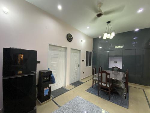 卡拉奇Modern Executive Suite的客厅里有一张桌子，墙上挂着一个钟