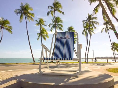 a blue and white chair sitting on the beach at Pousada Maceio é Massa Pajuçara Frente ao Mar in Maceió