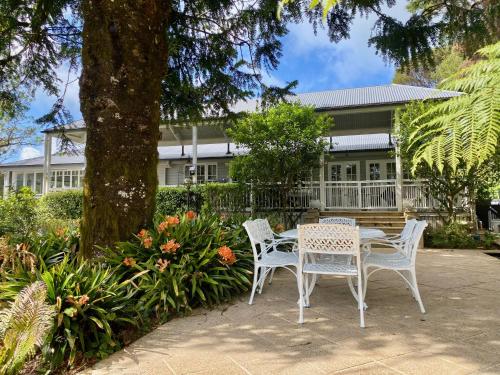 a table and chairs in front of a house at Tulip Gardens Estate - Spa, Sauna & Pet Friendly in Springbrook