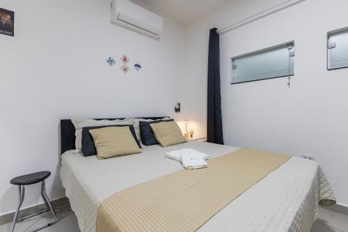 Suíte - Ideal para conexões no aeroporto de Guarulhos في جوارولوس: غرفة نوم بها سرير كبير مع كرسي