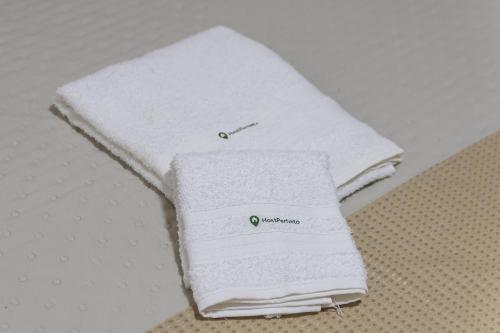 Suíte - Ideal para conexões no aeroporto de Guarulhos في جوارولوس: وجود منشفتين بيضاوين فوق طاولة