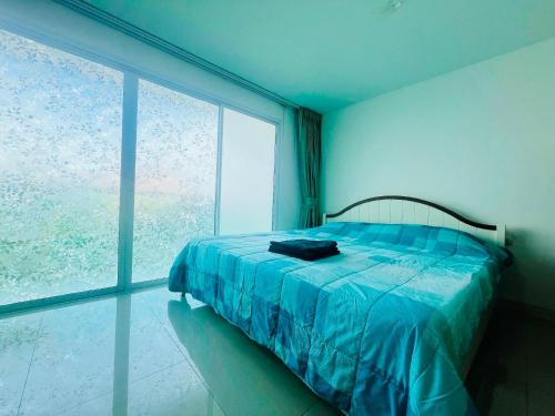 a bedroom with a bed and a large window at Bangsaray Beach B220 บางเสร่ บีช รายเดือน in Bang Sare
