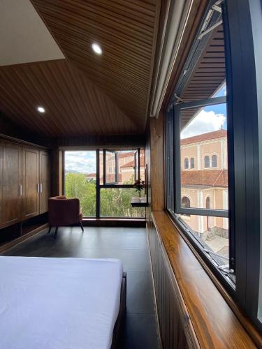 a bedroom with a bed and a large window at Căn hộ Đà Lạt Cảnh in Da Lat