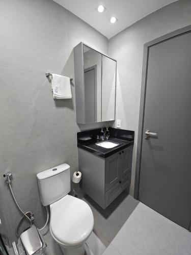 ein Badezimmer mit Toilette, Waschbecken und Spiegel in der Unterkunft Lindo Flat em Manaíra no Solaz in João Pessoa