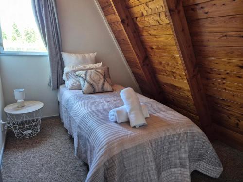 a bedroom with a bed with a stuffed animal on it at Aurora A-Frame Twizel in Twizel