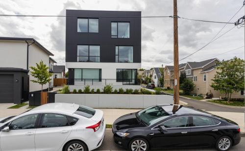 two cars parked in a parking lot in front of a house at Modern 4 & 5 BR Townhomes Minutes from Downtown LA in Los Angeles