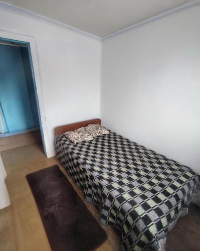 een slaapkamer met een bed met een geruite deken bij Marina 14norte 1530 in Viña del Mar