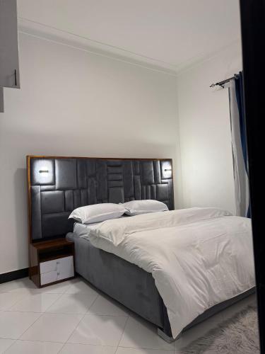 Un dormitorio con una cama grande con cabecero negro. en Dee furnished homes Kyanja, en Kampala