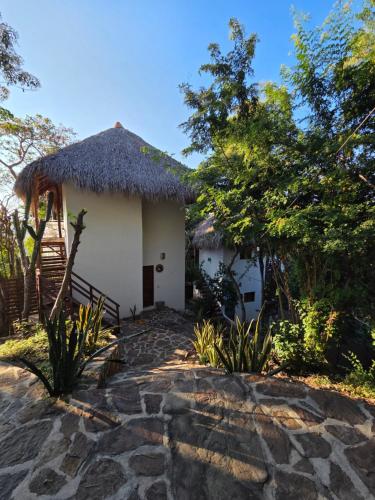 圣奥古斯蒂尼罗Ruunda, Hotel的一间茅草屋顶的小屋和一条石板路