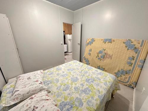 a bedroom with a bed with a quilt on it at Casa com 02 Quartos em Balneário Camboriú in Balneário Camboriú