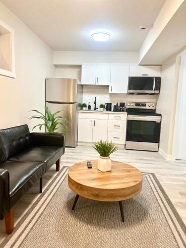 a living room with a black couch and a coffee table at Cozy guest house in Regina