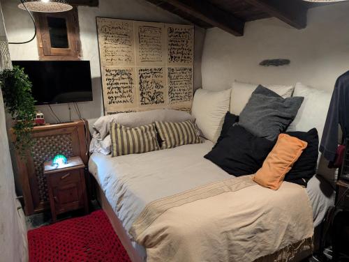 een bed met kussens in een kamer bij Patones Experience Room in Patones