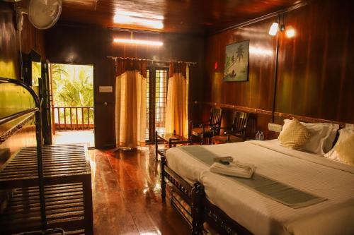 Una cama o camas en una habitación de Backwater Retreat Kumarakom