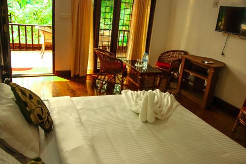 Una televisión o centro de entretenimiento en Backwater Retreat Kumarakom